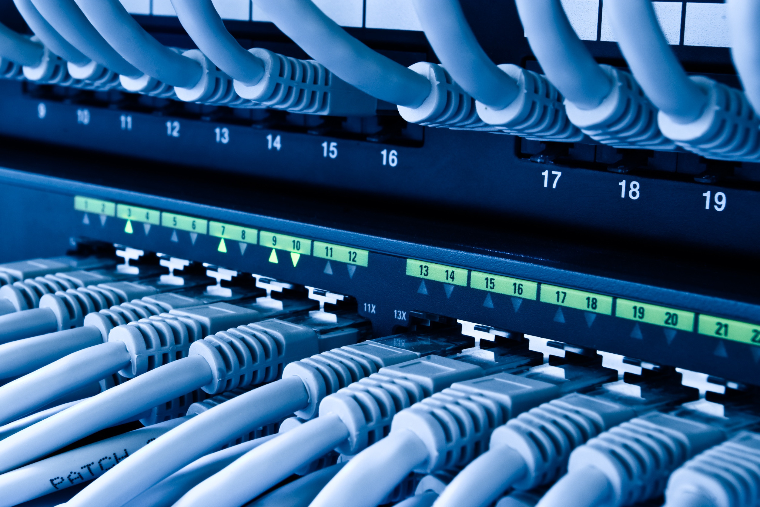 Close-up of a network panel filled with numerous colorful wires connected to various ports.
