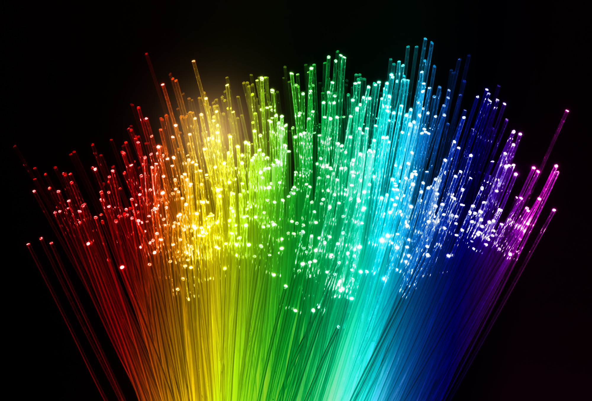 A vibrant rainbow-colored fiber optic cable illuminated with numerous bright lights, showcasing its colorful design.